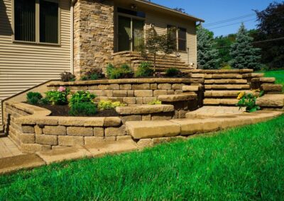stone patio with stairs and plants along wall